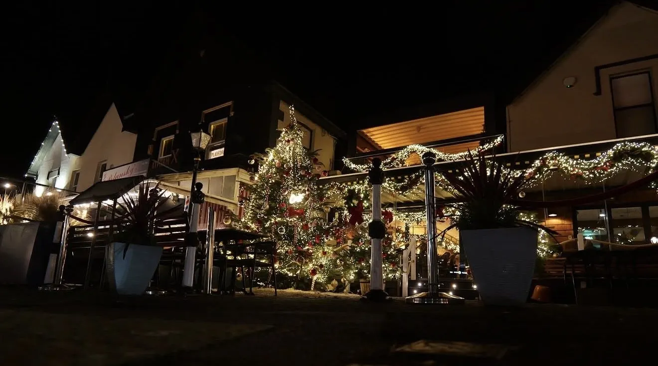 Coast lit up for Christmas with a decorated tree and garlands